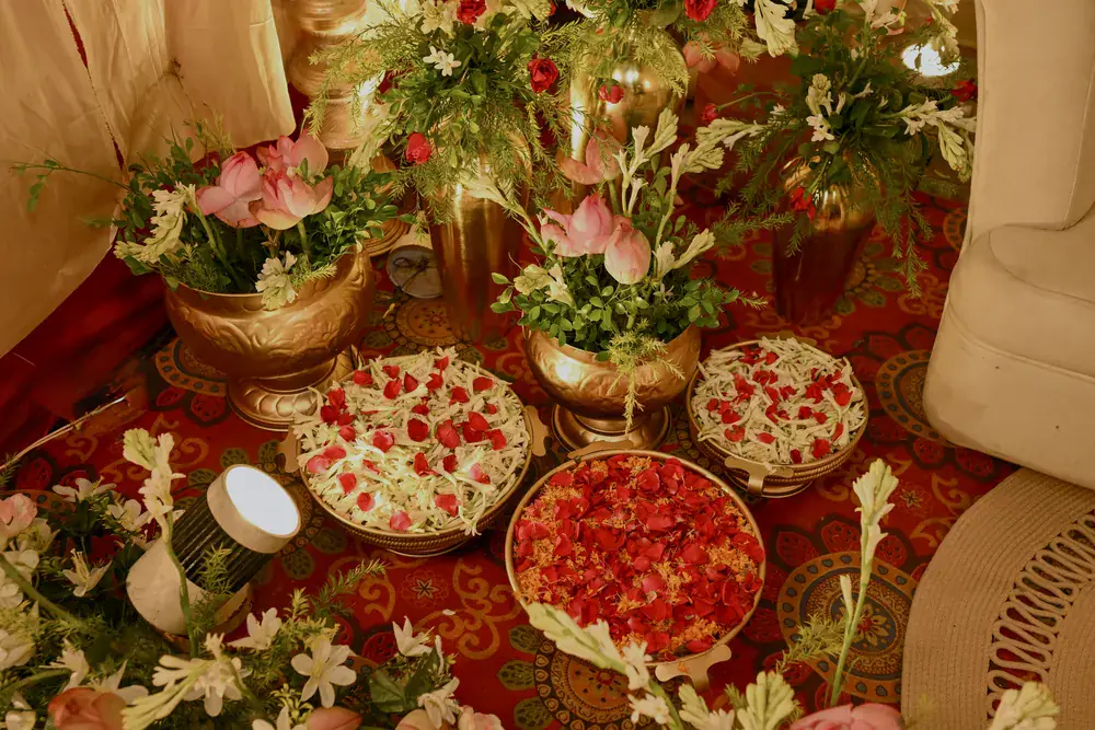 Brass urns of lilies beside platters of rose petals