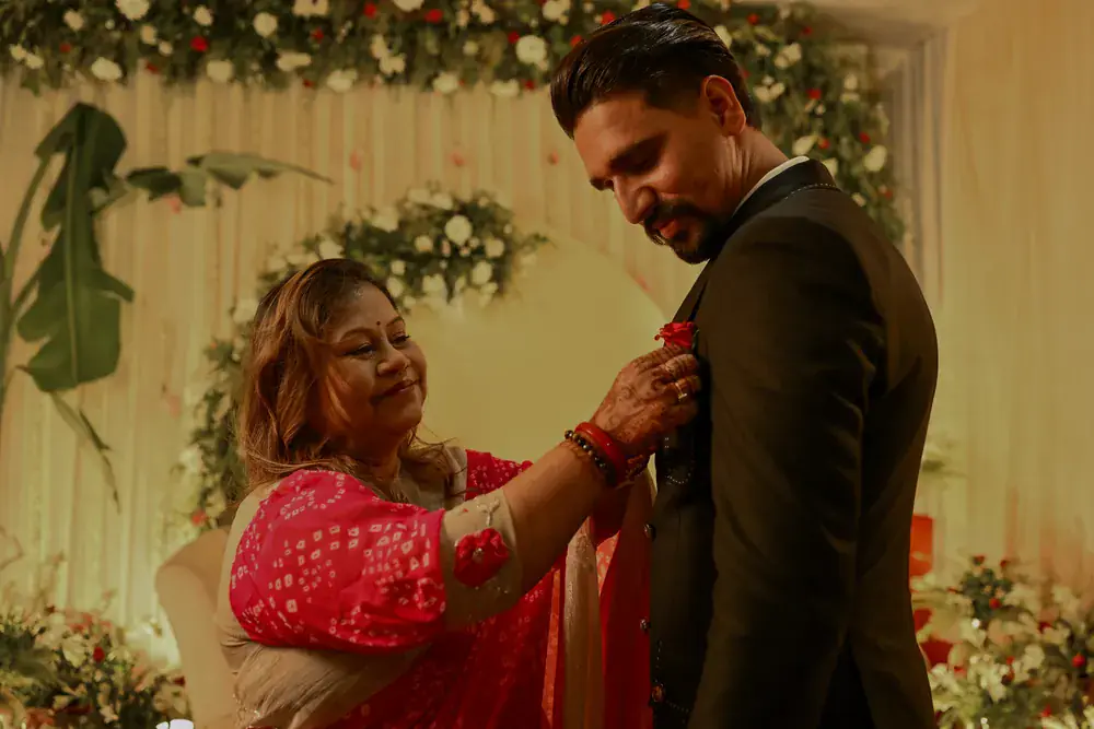 A rose pinned to Sumit's lapel by a smiling relative