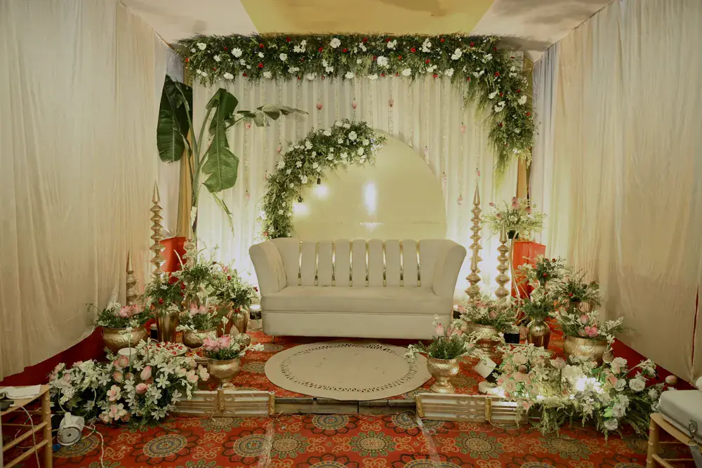 The engagement stage dressed in ivory drapes, white florals and brass