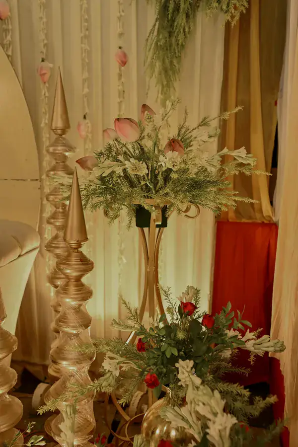 Tall brass finials and florals at the side of the stage