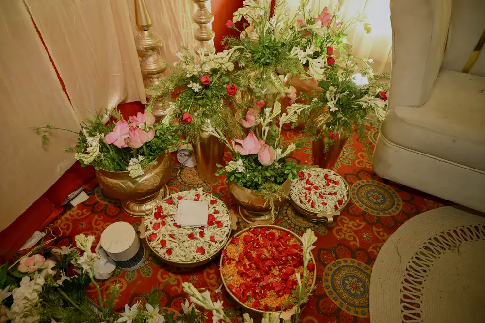 Petal platters and urns of pink lilies at the edge of the stage
