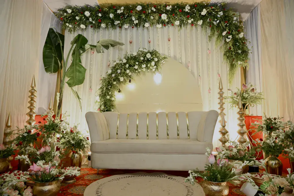 The stage from the front: the sofa, the floral arch and brass urns
