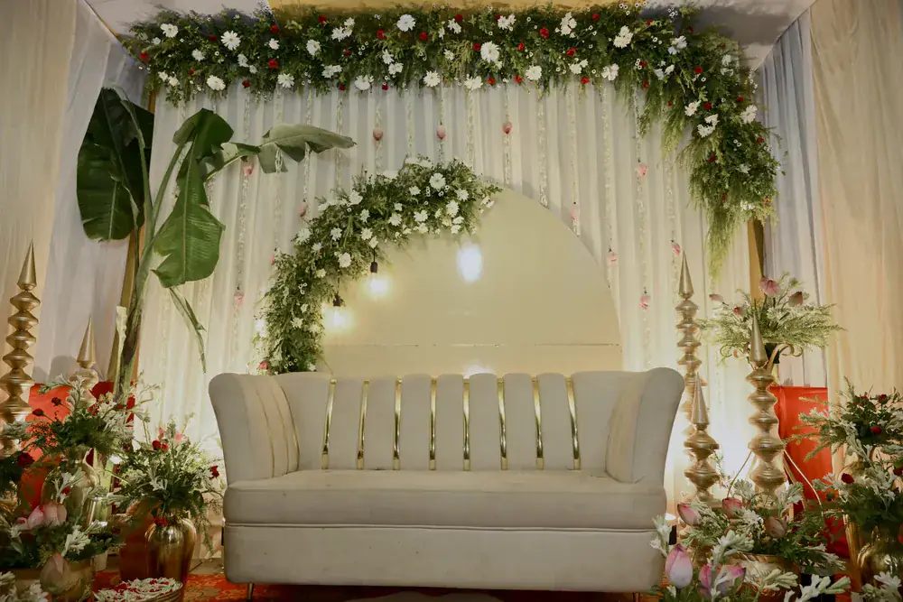 The stage sofa beneath the floral arch